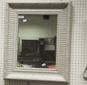 A white painted wall mirror with reeded and beaded decoration