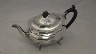 A silver teapot of faceted form with ebony handle and finial, raised on four swept feet (Birmingham,