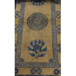 A Chinese throne rug, the central medallion in blue and black, on a pale cinnamon ground,