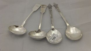 A pair of George V silver spoons with pierced ends and a pair of Victorian silver sauce ladles,