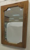 An oak framed rectangular wall mirror with shaped frame