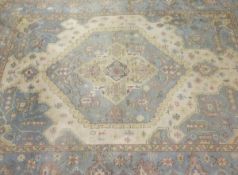 An Indian rug, the central medallion in cream, pale sand, pale blue, pale yellow and pale salmon,