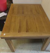 A modern rectangular light oak draw leaf dining table on square supports