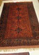 A Caucasian rug, the three central star shaped medallions in black and terracotta,