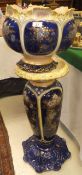 A Victorian pottery jardinier on stand decorated in the Art Nouveau taste with flowers on a cobalt