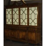 A Portuguese mahogany breakfront display cabinet with swan neck moulded pediment over four astragal