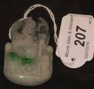 A Chinese jade carved pendant depicting a seated figure with a torch