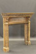 An oak fire surround with ogee moulded cornice above heavily carved frieze featuring head and