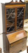 A mahogany and cross-banded bureau bookcase with swan neck pediment above two astragal glazed doors