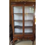 A mahogany two door display cabinet enclosing four shelves with two drawers below,