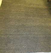 A large modern textured loop pile carpet in plain grey/brown,