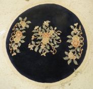 A Chinese circular rug decorated with floral sprays in pink,