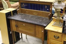 An Edwardian oak washstand, the tiled back above marble top, with single cupboard door,