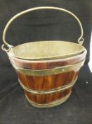 A 19th Century fruitwood coopered and brass bound oval bucket with liner and swing handle