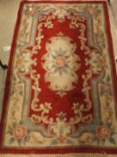 Two Chinese superwash rugs in red, cream and pale green,