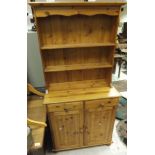 A late 20th Century pine dresser with two open shelves above a base of two drawers and two cupboard