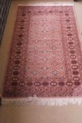 A Bokhara rug, the central mushroom ground with repeating medallions within mushroom,