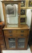 An oak shop display cabinet with three shelves and single glazed door,