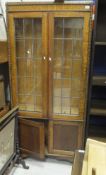 A 1920's oak and leaded glazed display cabinet with applied beaded decoration