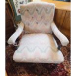A pair of mahogany framed armchairs in the Howard manner, upholstered in peach, green and cream,