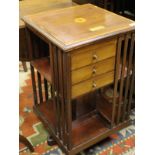 An Edwardian mahogany and crossbanded revolving library bookcase with three drawers bearing brass