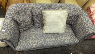 An early 20th Century drop arm two seat sofa in blue patterned upholstery,