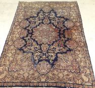 An Oriental carpet, the central floral decorated medallion in cream, green,