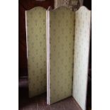 A four fold vanity screen upholstered in a cream ground foliate patterned fabric