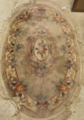 A Chinese superwash oval rug in cream, pink, green and mushroom,