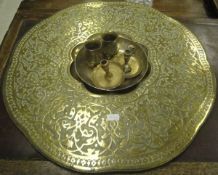 A large Eastern brass tray with flower shaped well to centre and blind fretwork design to rim,