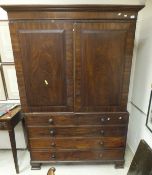 A Regency mahogany linen press, the upper section with two cupboard doors enclosing a hanging space,