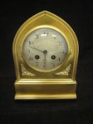 A brass cased mantel clock of lancet form,