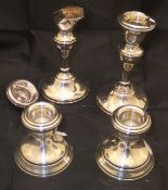 A pair of silver sheathed squat candlesticks,