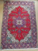 An Oriental carpet, the central floral decorated medallion in cream, blue,