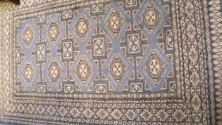 A Bokhara rug, the central repeating medallions in cream,