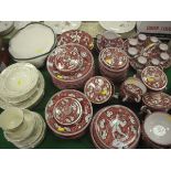 A collection of Italian pottery table wares decorated in burgundy and black on a cream ground,