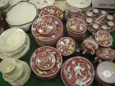 A collection of Italian pottery table wares decorated in burgundy and black on a cream ground,