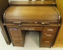 An early 20th Century oak tambour fronted desk of eight assorted drawers,