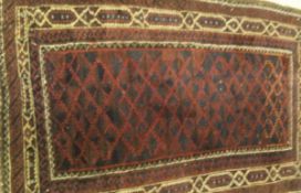 A Caucasian rug, the central diamond shaped design in aubergine, blue/black and burgundy,