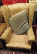 An early 20th Century wing back armchair upholstered in salmon damask fabric,