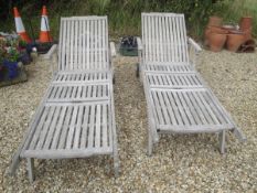 A pair of teak garden loungers / steamer chairs,