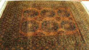 A Bokhara rug, the six elephant foot medallions in black, cinnamon and madder on a cinnamon ground,