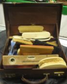 A leather suitcase containing assorted 19th Century ivory backed brushes, various wallets,