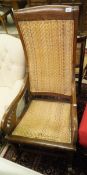 An oak framed rocking chair with scroll arms and canework seat and back