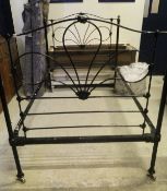 An Edwardian black painted tubular and wrought iron single bedstead with brass finials