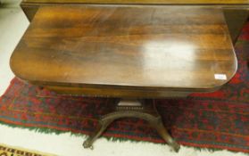 A Victorian rosewood fold over card table raised on square tapering pedestal to quadruped base with