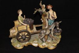 A large capo-di-monte figure group of a grape picker with donkey and boy in cart,
