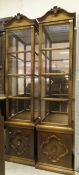 A pair of modern three sided glazed display cabinets with mirrors to back raised on plinth bases