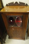 A mahogany Victorian music cabinet with single door set with two oval bevel edged mirrors the whole