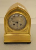 A brass cased mantel clock of lancet form,